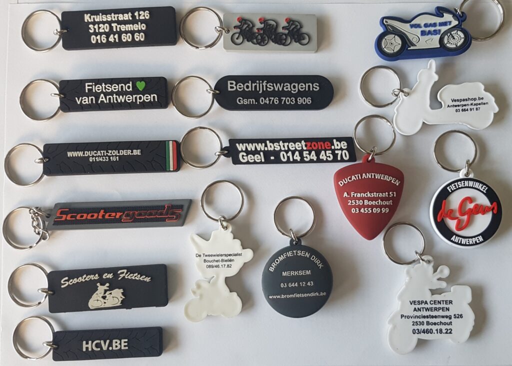 Overzicht van gepersonaliseerde sleutelhangers met logo, tekst en verschillende vormen voor fiets-, motor- en autobedrijven.